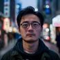 东京影迷用户头像，戴眼镜的男性，背景为日本街道