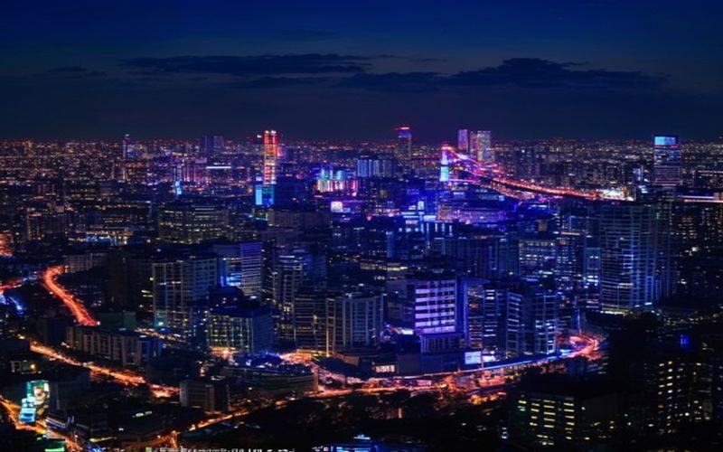 日本东京演艺区夜景，霓虹灯光映照下的剧场建筑群，繁华都市中的文化艺术地标